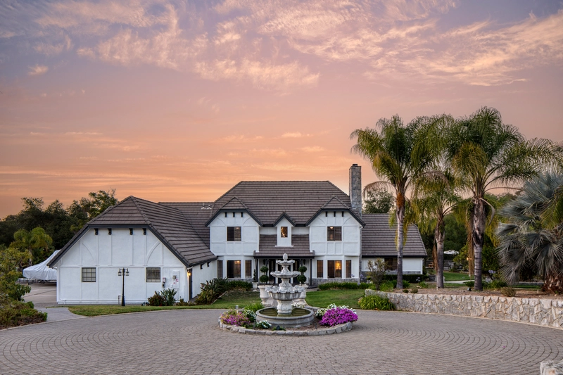 victorian white and 2-story mansion with a circle around and fountain
