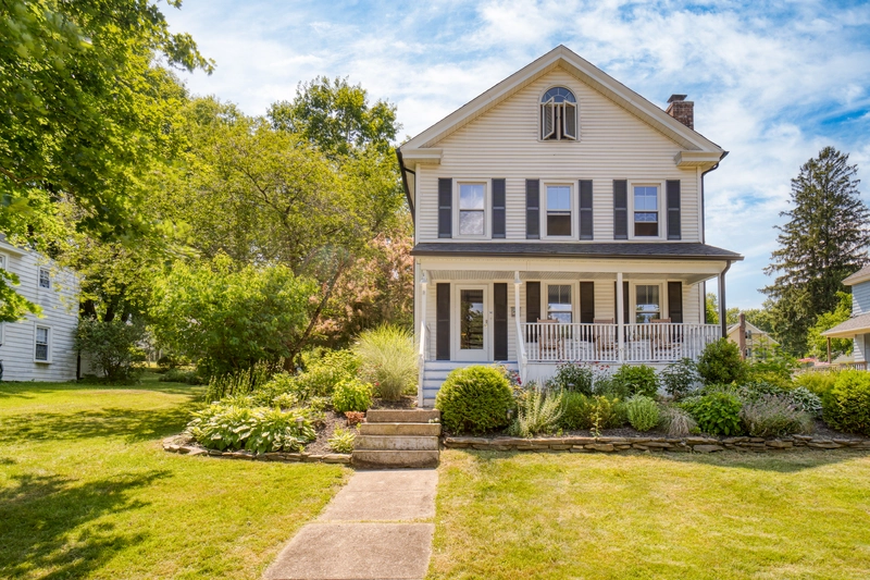 2 story house with groomed yard patio and bushes