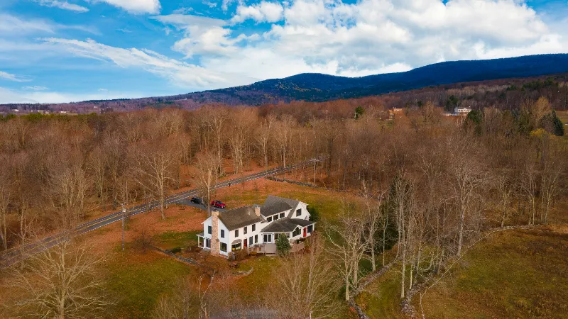 secluded american white house by the woods during autumn foliage