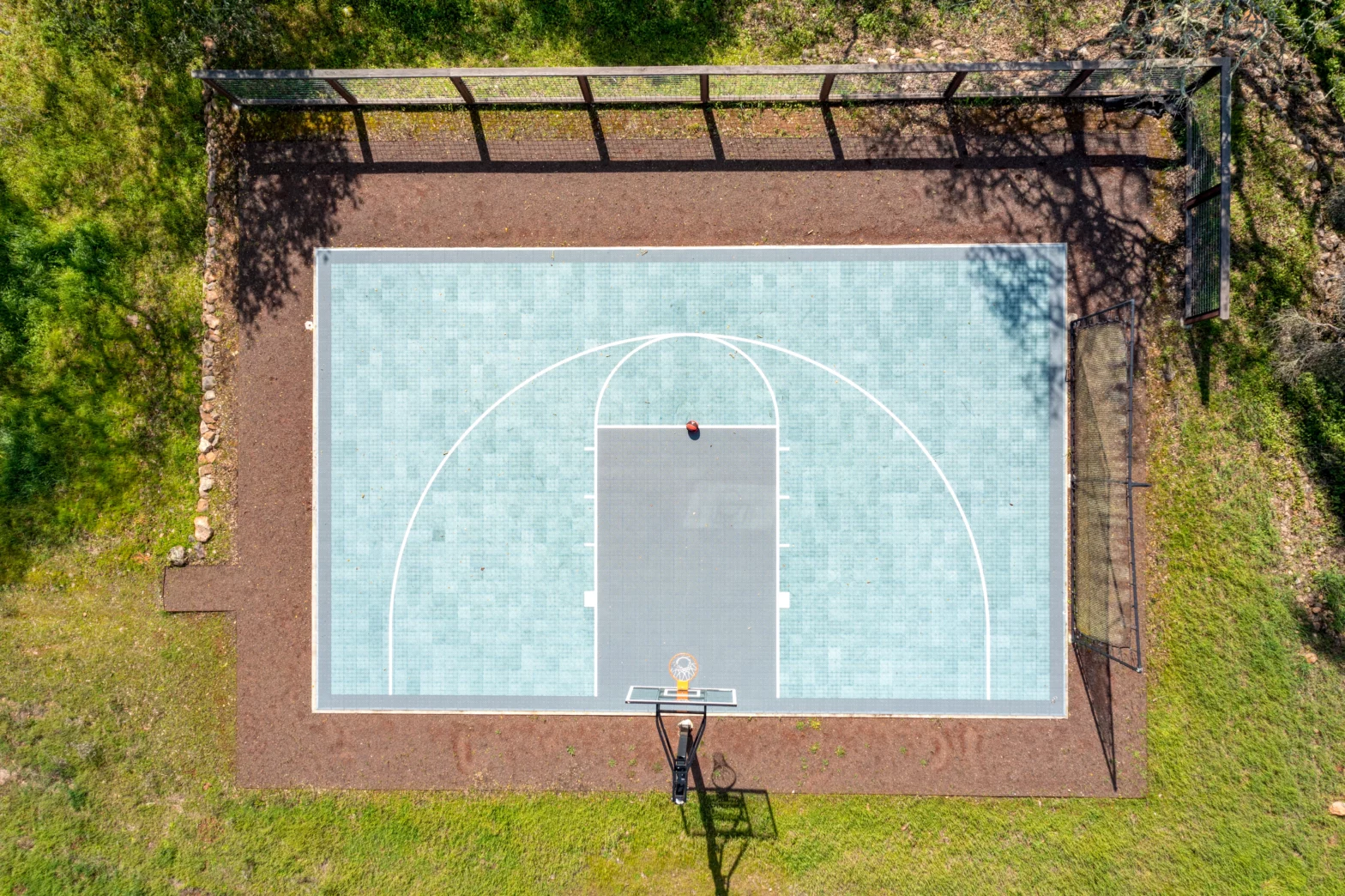 big rectangular basketball court in eagle's view with turquoise lined floor