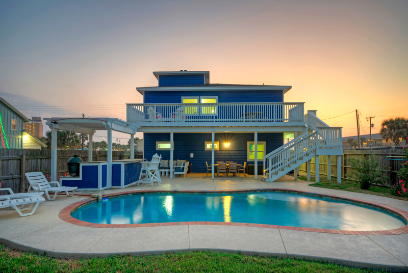 blue wooden beach house with sailor white rails and stairs and a pool making it the best port aransas airbnb