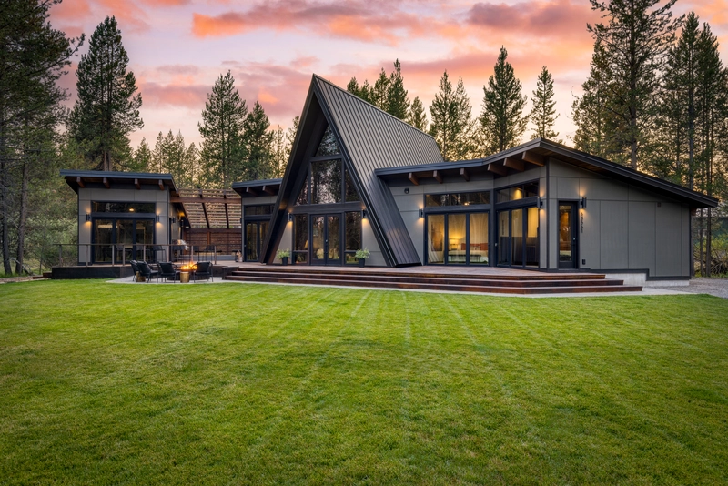 triangle roofed house with big green lawn and pink cotton candy skies making it the best oregon airbnb
