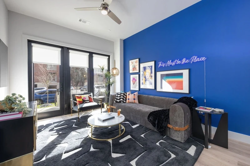 royal blue big wall with picture frames and modern black monotone furniture making it the best Nashville airbnb