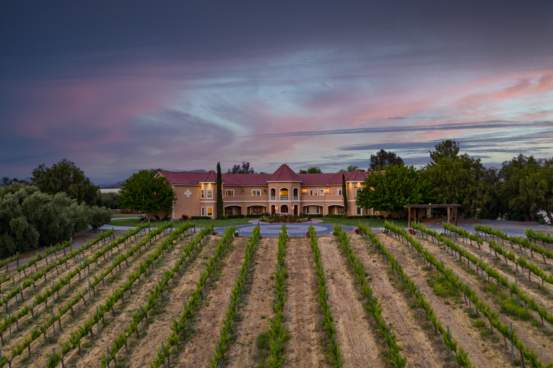storybook mansion with red brick cone roofs and rows of plants making it the best Temecula airbnb