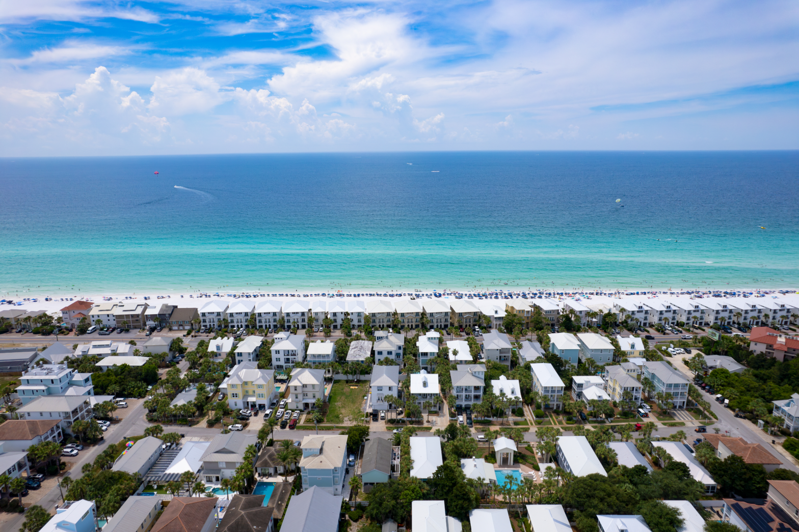 turquoise blue beach with white sands and beach homes along the coast line