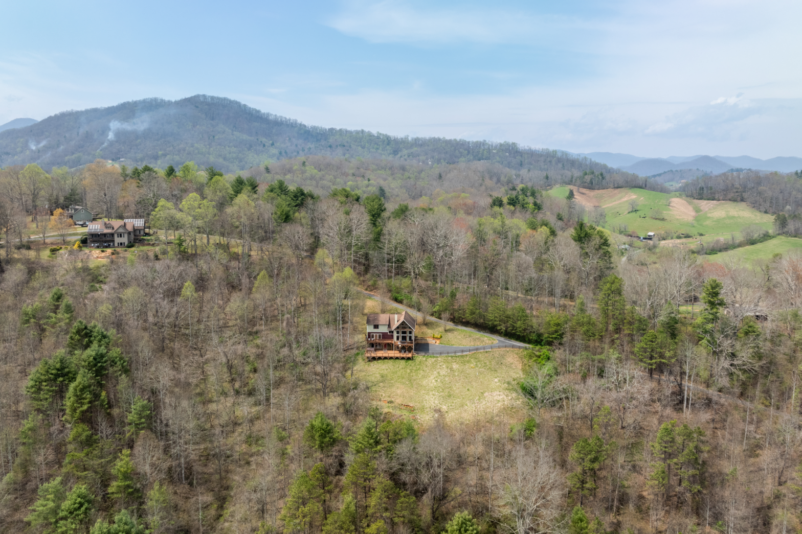 a wood cabin log house in the middle of green trees and mountain making it the best asheville airbnb