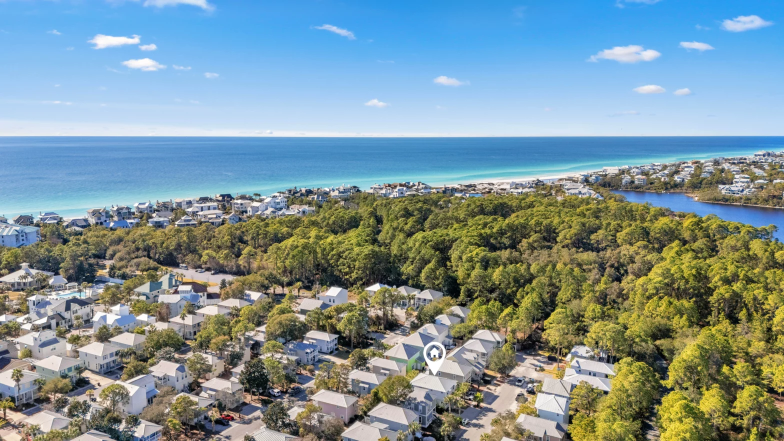 drone shot of the turquoise Florida beach with a subdivision of Airbnb 30a homes