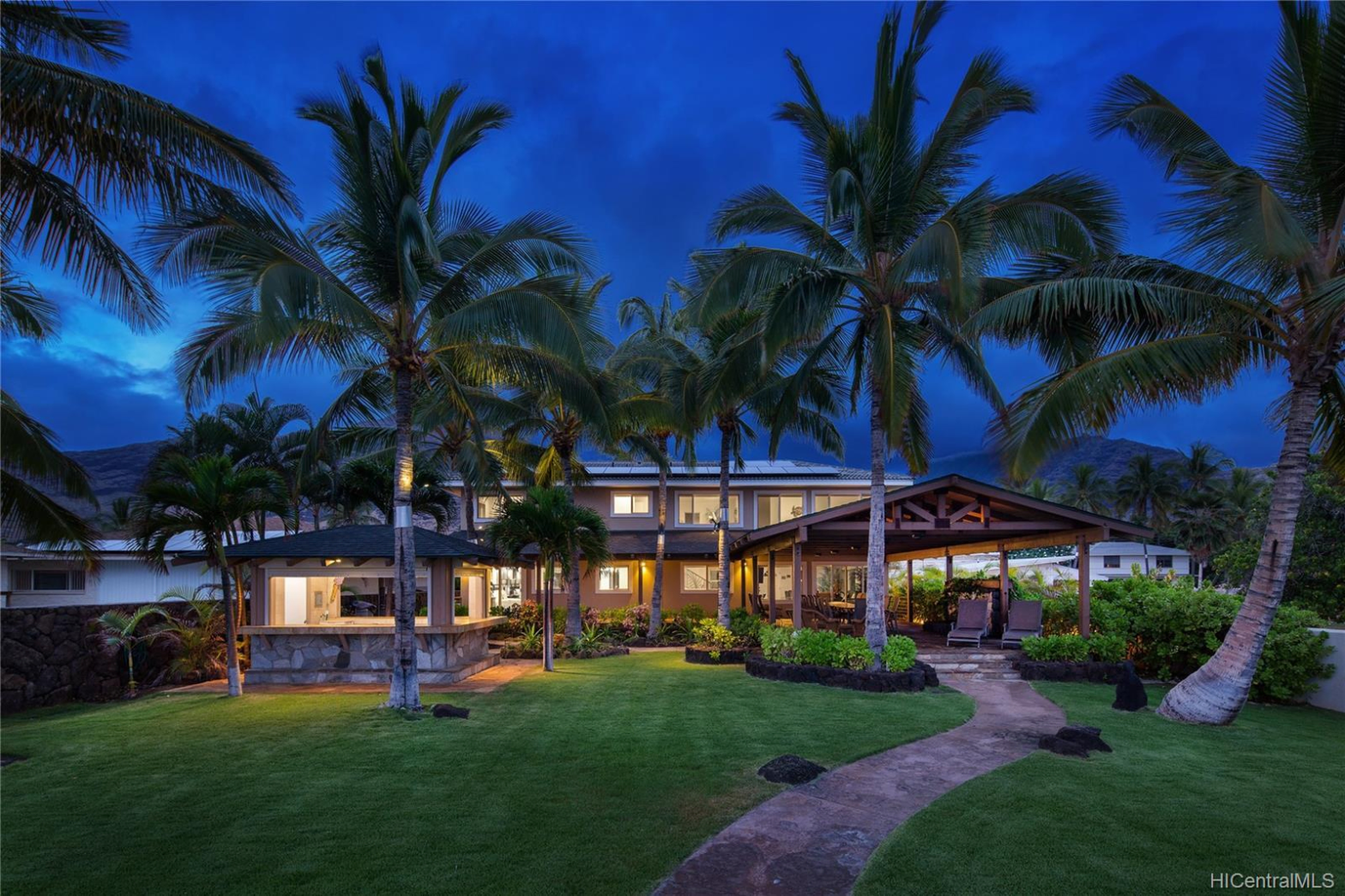big cottage house with coconut trees swaying by the beachfront