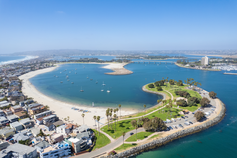 blue beach lagoon with white sands and palm trees under the summer sun making it the best places to visit in august