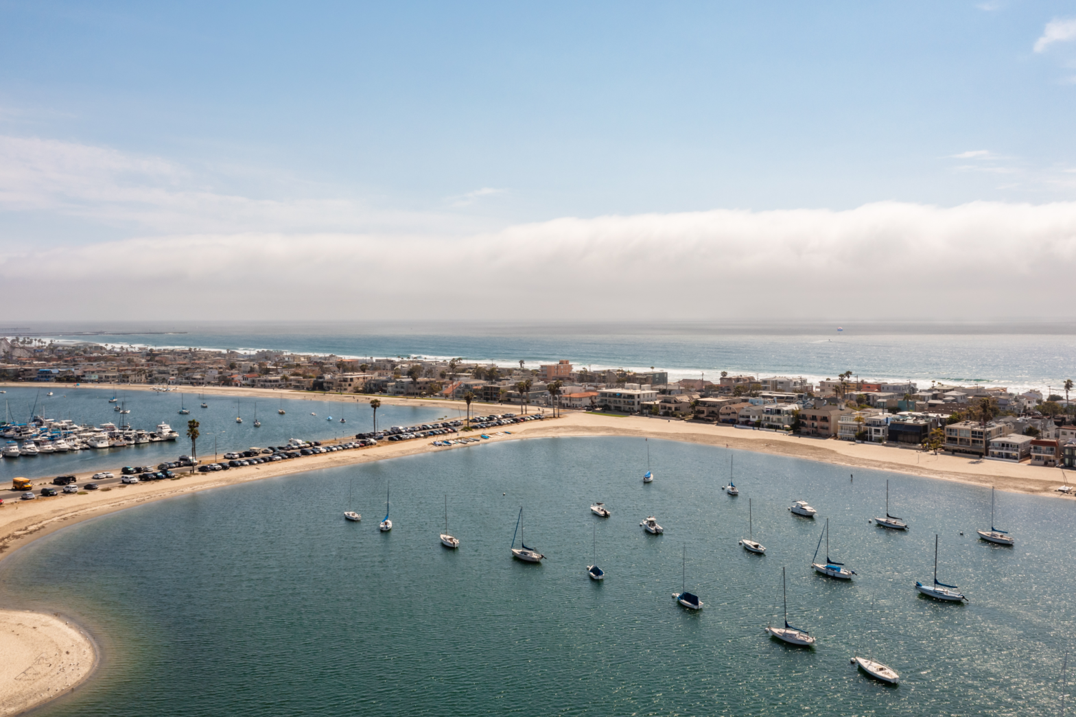 blue beach with parked yachts along the shoreline and coast of san diego