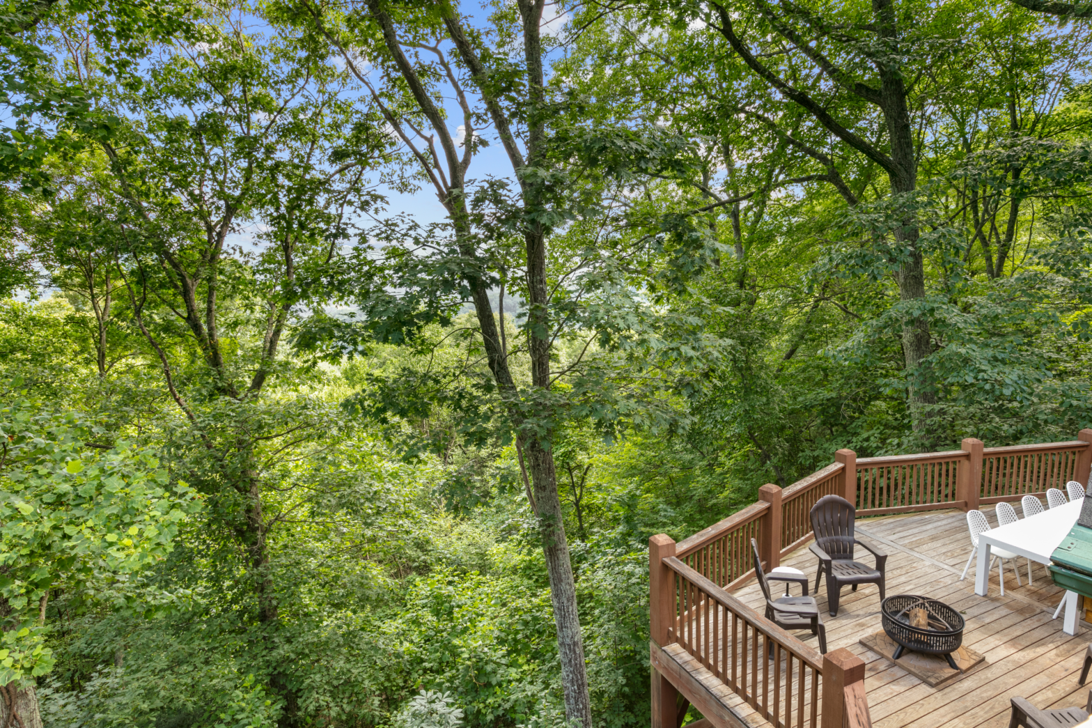 a tree house high up in the forest with wooden deck and views