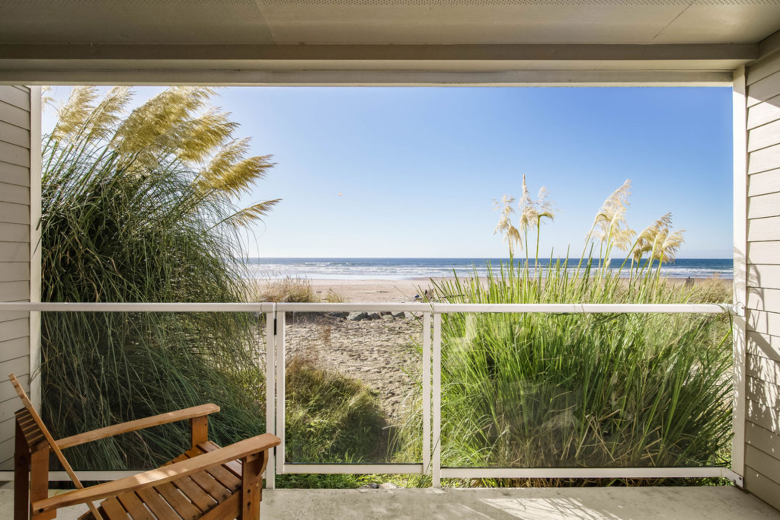green bush on the beach sand and with a balcony and rocking chair