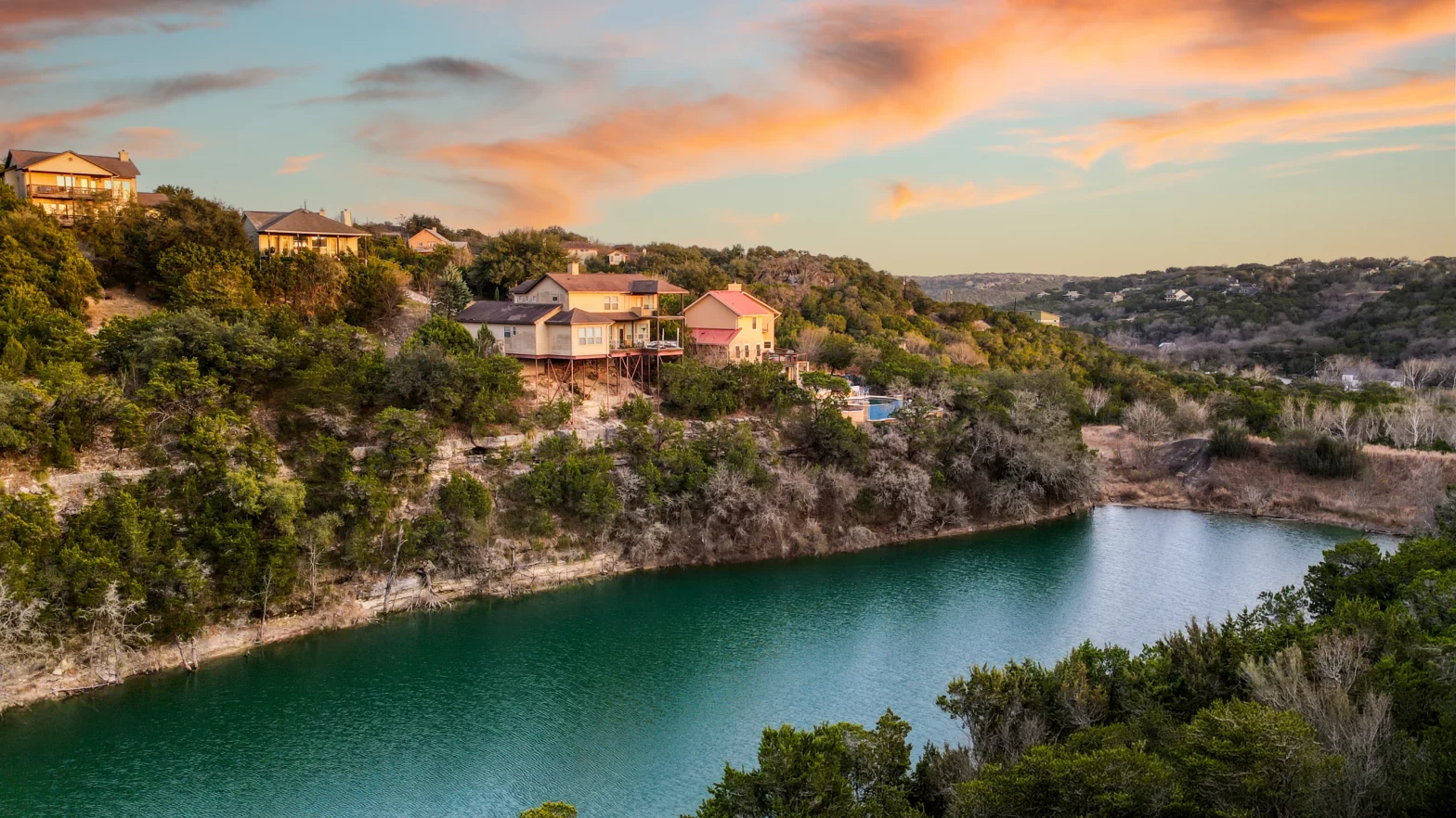 dark green river with green lush trees and candy cotton skies of Austin