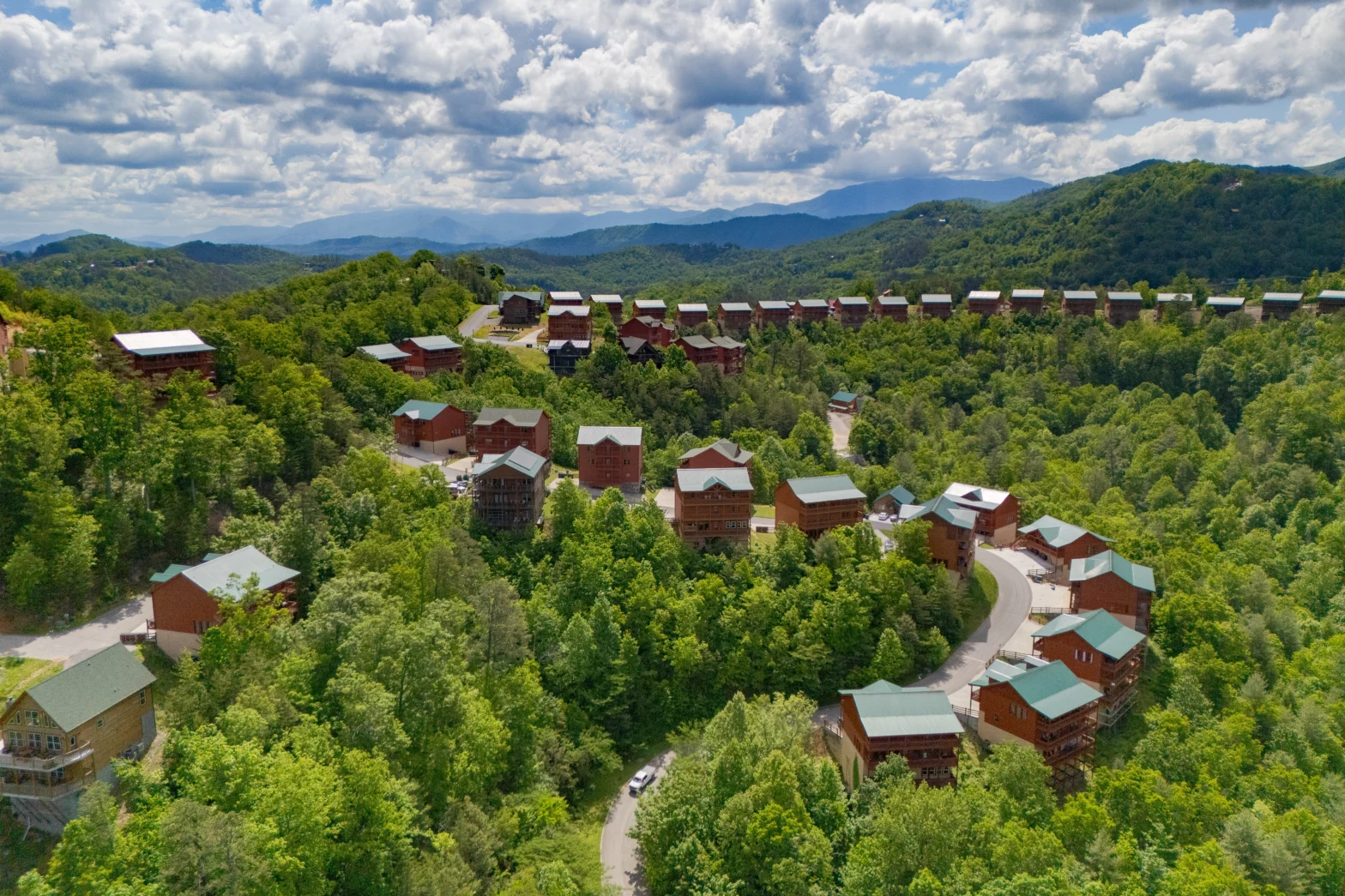 eagles's view of the green mountain with cabin houses like trains lined up
