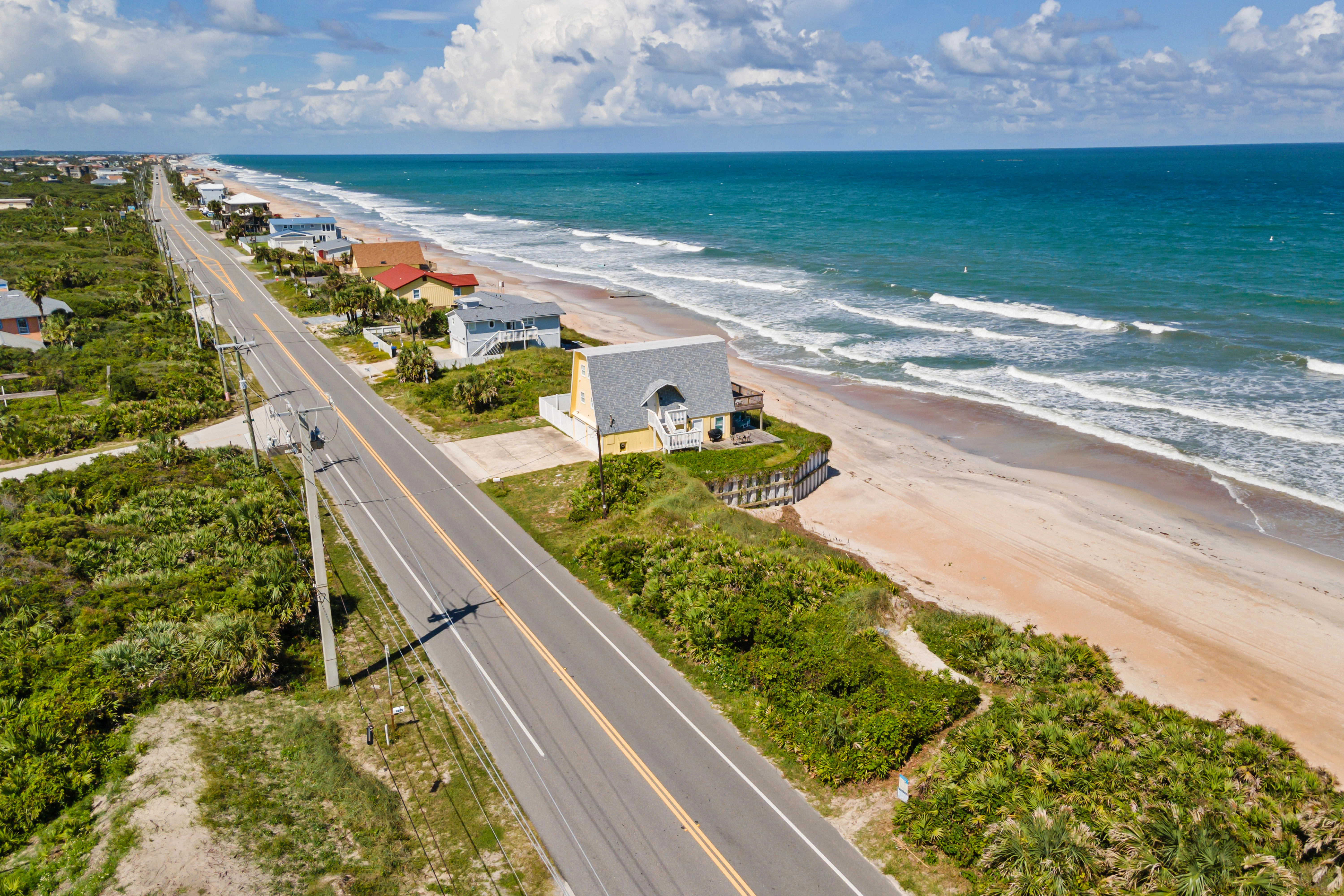 a coastal road by the waves and sands of the beach nearby