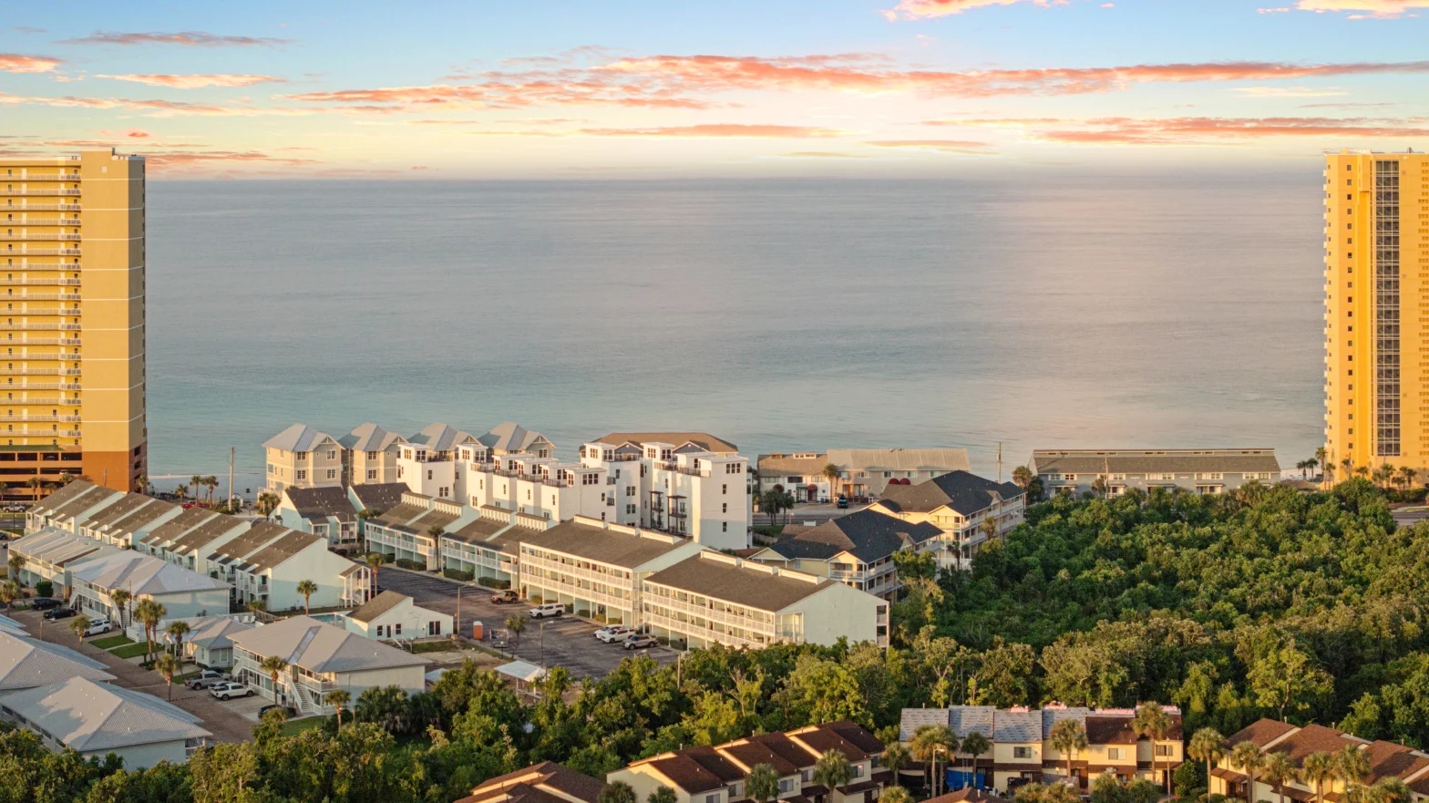 2 gold buildings left and right with a blue ocean in the middle and houses