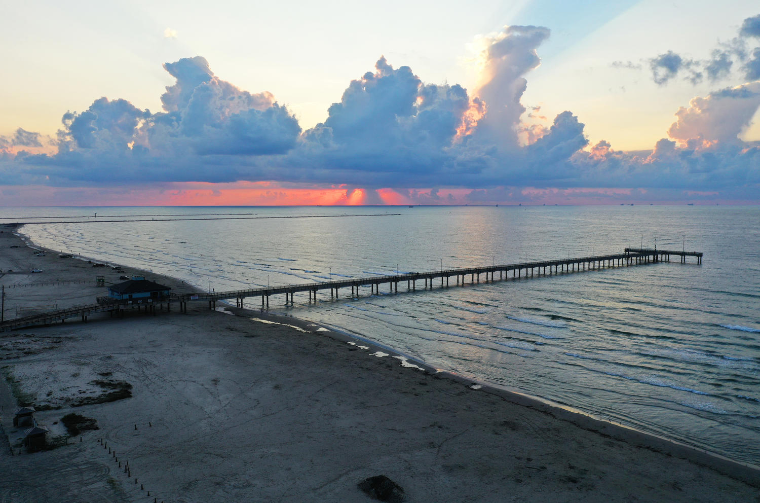 long board walk to the calm waters of the ocean after sunset