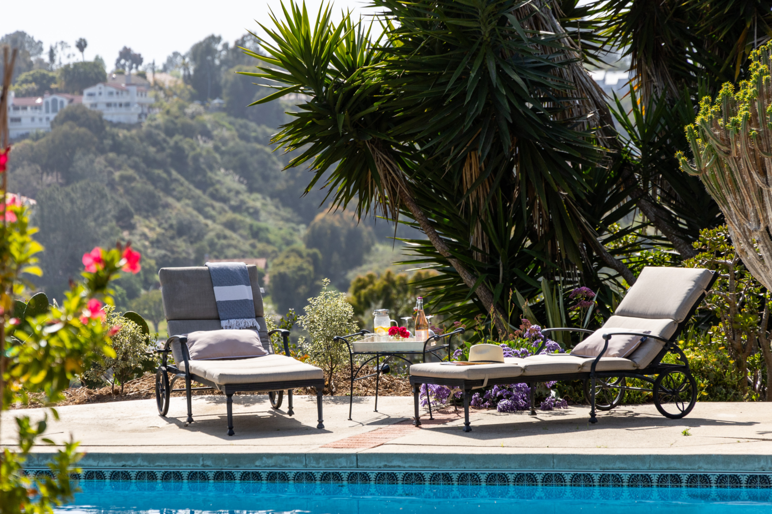 two elegant brass sun loungers by the blue swimming pool