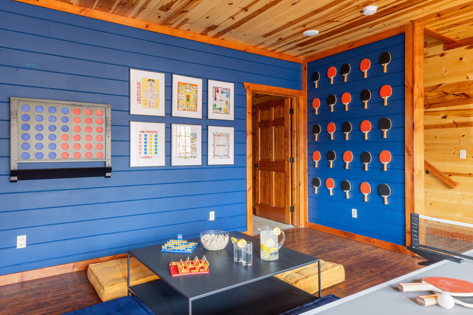 blue walled cabin house with red and blue ping pong paddles and picture frames