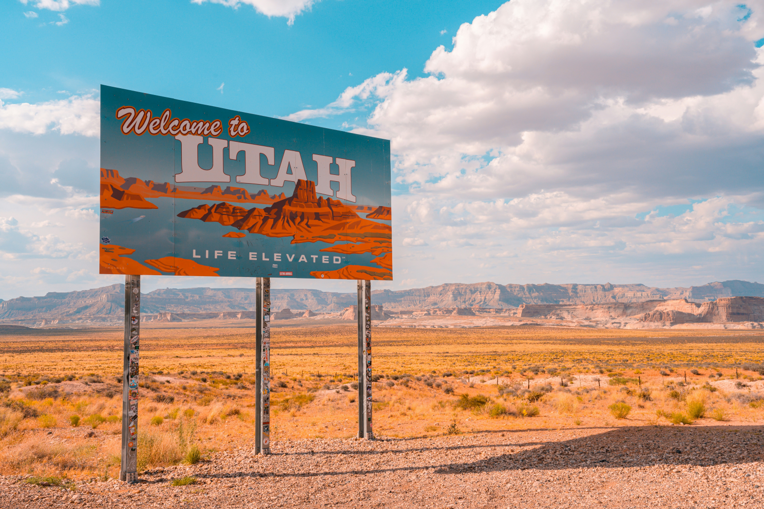 billboard by the dry sand desert saying welcom to Utah