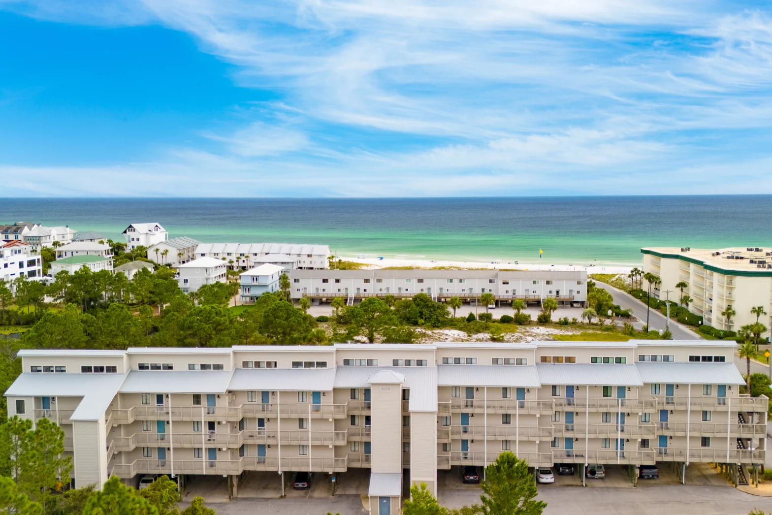 large building complex facing the emerald sea and white sand beach